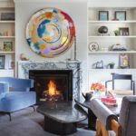 Marble living room fireplace with colorful circular art work.