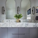 Primary bathroom with gray cabinetry and marble countertop