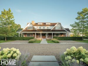Exterior of a shingle style Martha's Vineyard house with a large gravel driveway.