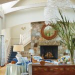 Coastal living room with large natural stone fireplace.