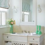 Coastal bathroom with a white vanity and green accents.