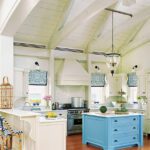 Coastal kitchen with white cabinetry and a bright blue island.