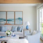 Comfortable seating area with a triptych of coastal wall art.