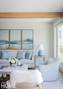 Comfortable seating area with a triptych of coastal wall art.