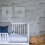 Nursery with a white crib and whale wallpaper.