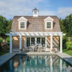 Exterior of a classic ape Cod pool house and rectangular pool