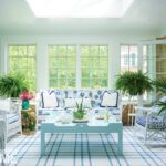 Sunroom with white walls, plaid carpeting and a floral couch