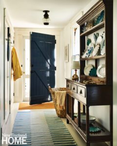 Entryway with blue door and antique Welsh dresser.