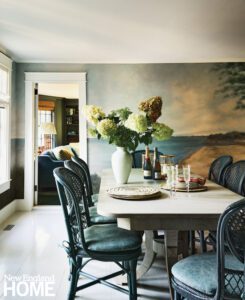 Dining room with a hand painted mural and cane-back chairs.