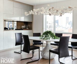 Contemporary dining area with a round table and sculptural chandelier.