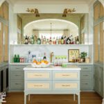 Bar nook with like pale blue cabinetry and brass lighting.