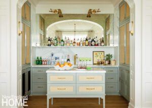 Bar nook with like pale blue cabinetry and brass lighting.