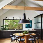 Kitchen with vaulted ceiling and a large black pendant light.