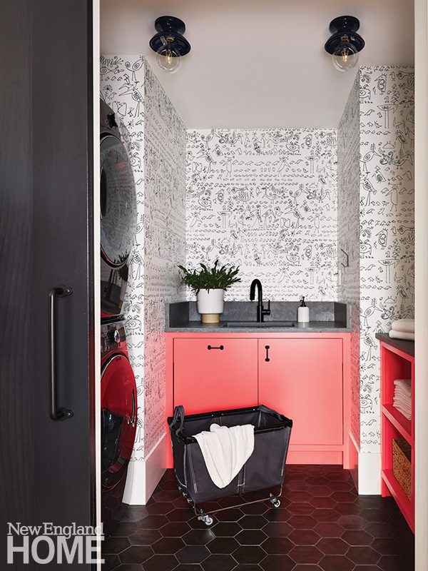 Laundry room with graphic black and white wallpaper and red cabinetry.