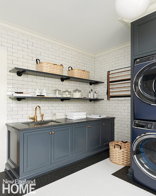 Laundry room with gray cabinets and white subway tile.
