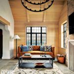 White oak clad family room with soaring ceilings and large black metal chandelier.