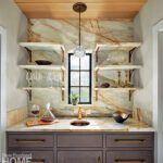 Butlers pantry with marble shelves and brass accents.