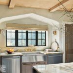 Stainless steel kitchen sink recessed in a Tudor arch.