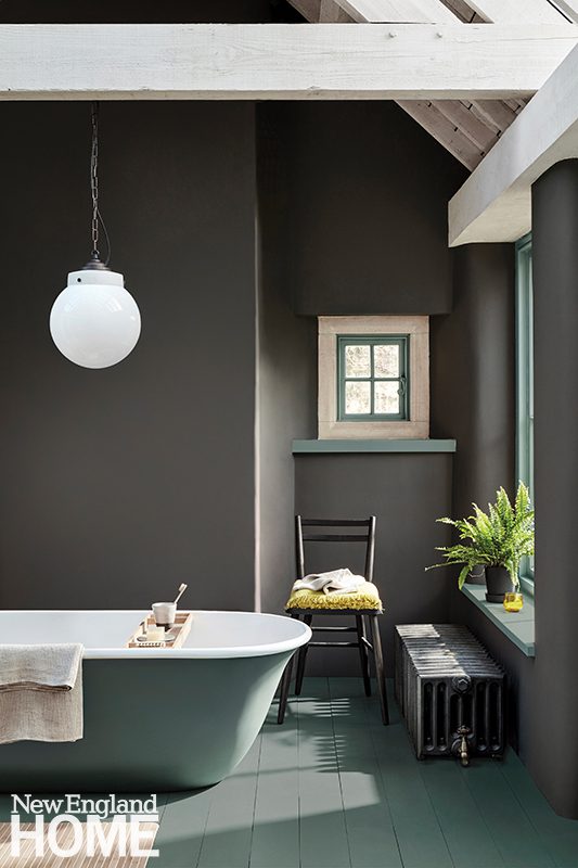 A bathroom is painted in Little Greene's Vulcan, a deep charcoal gray. 
