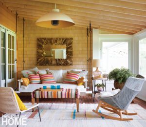 Three season porch with natural wood and a sofa swing.