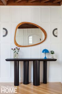 Black contemporary console with a midcentury modern mirror.