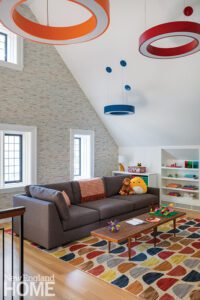 Playroom with bright colors ad a dark gray couch.
