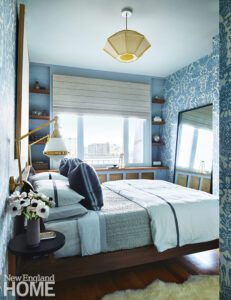 Small apartment bedroom with blue and white wall paper.