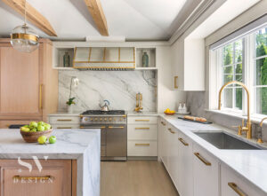 A bright white kitchen with a marble back splash and white oak accents