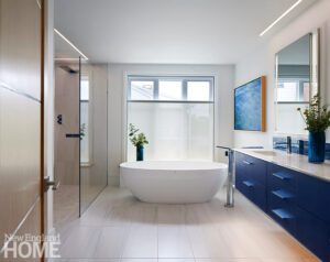 Contemporary bathroom with a floating blue vanity and freestanding white tub.