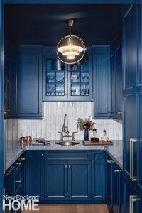 Bright blue pantry with a gold pendant