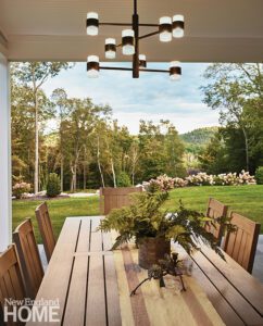 Outdoor porch with wood table and contemporary chandelier