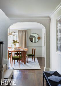 Dining room with a rectangular wood dining table and chairs with upholstered green seats.