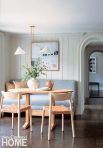 Light blue banquette with a light wood table and chairs