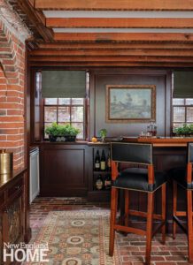 Home bar with brick wall and dark cabinetry