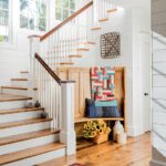Entrance and stairs to a Shingle-style home with pine furnishings and quilts