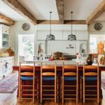 Country-style kitchen with wooden beams on the ceiling and a large island.
