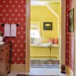 Guest bathroom with red and white patterned wall paper.