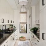 Pantry with white cabinets and a black countertop
