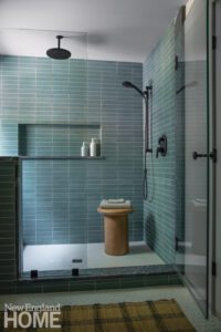 Walk in shower with penny tile floor and light blue tile walls