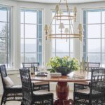 Dining area with a large round table and two-tiered brass chandelier