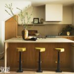 Contemporary kitchen with white oak cabinetry and yellow leather stools.