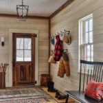 Rustic mudroom with pale wood paneling.