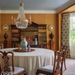 Dining room with a round table, antiques, and crystal chandelier