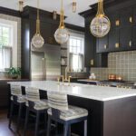 Kitchen with dark cabinetry and a large island topped with white stone.