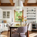 Open plan kitchen with natural wood beams and white cabinetry