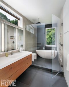 Contemporary bathroom with a floating oak vanity and white soaking tub