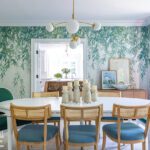 Dining room with floral wallcovering and rattan chairs.