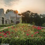 Large stone home with a grand rose garden