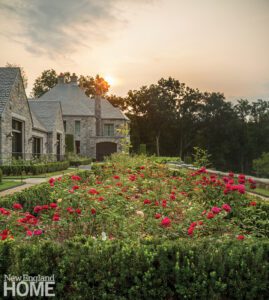 Large stone home with a grand rose garden