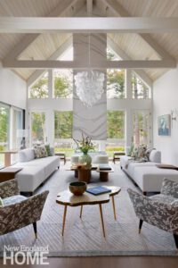 All white room with a bubble chandelier and wall of windows